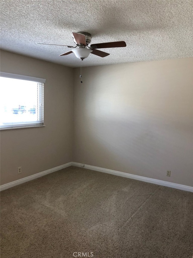 unfurnished room with ceiling fan, a textured ceiling, and carpet