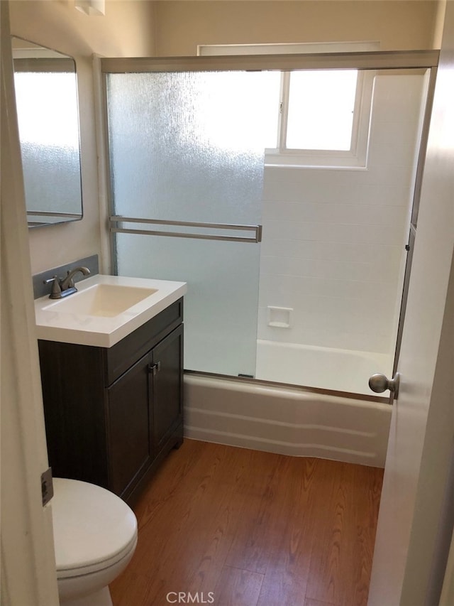 full bathroom with vanity, hardwood / wood-style floors, plenty of natural light, and shower / bath combination with glass door