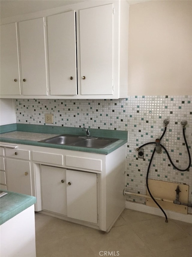 laundry room with cabinets, hookup for a washing machine, sink, and light tile patterned floors