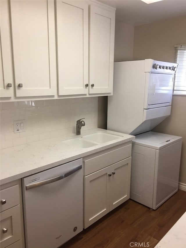 washroom with stacked washer / drying machine, dark hardwood / wood-style floors, and sink