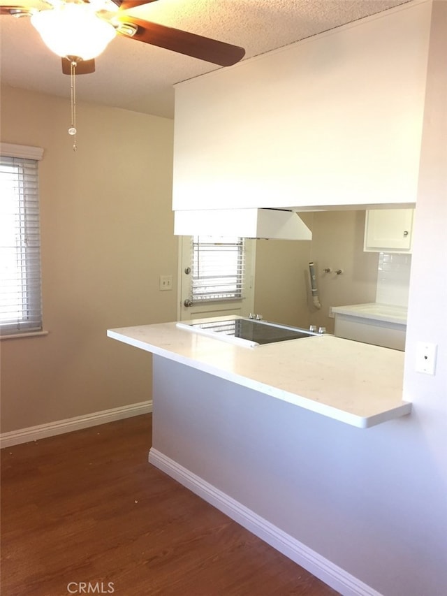 kitchen featuring white cabinetry, black electric stovetop, dark hardwood / wood-style floors, and kitchen peninsula