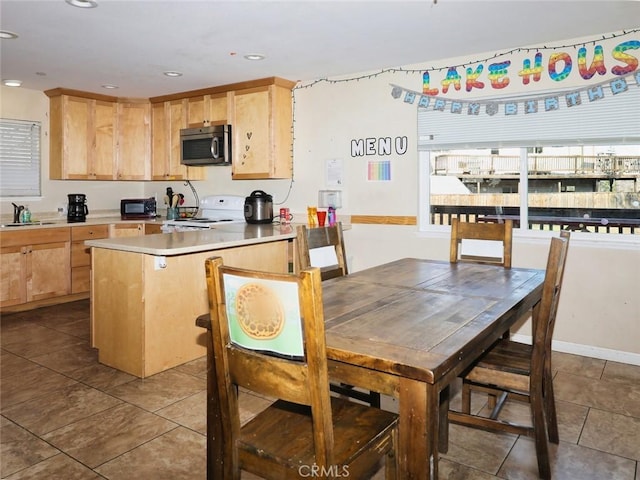 kitchen featuring tile patterned flooring, sink, light brown cabinets, and white range with electric cooktop