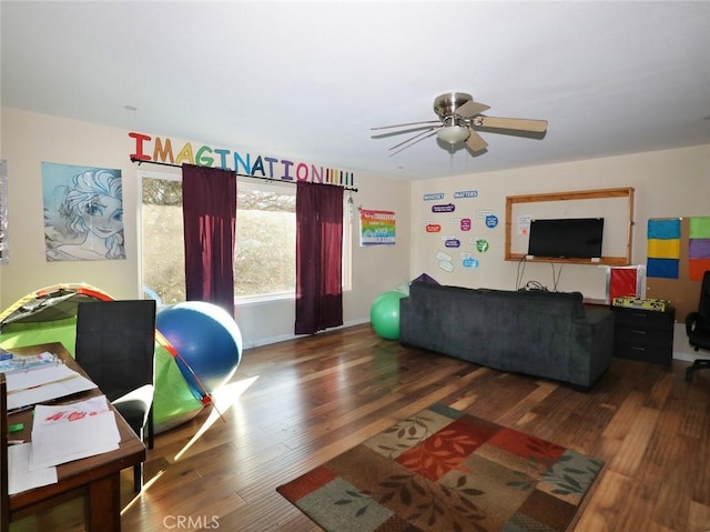 living room featuring dark wood-type flooring and ceiling fan