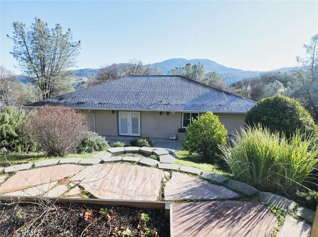 rear view of house with french doors, a mountain view, and a patio