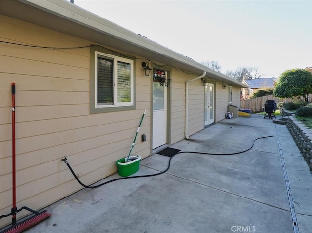 view of property exterior featuring a patio area and fence