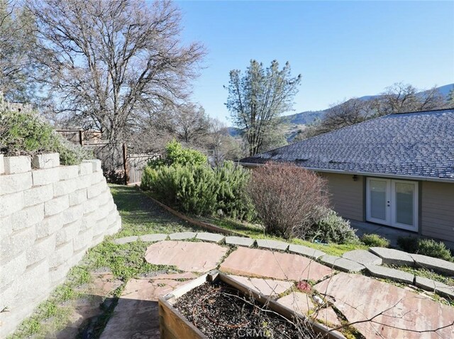 view of yard with french doors and a mountain view