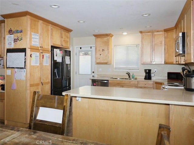 kitchen featuring stainless steel appliances, kitchen peninsula, sink, and light brown cabinets