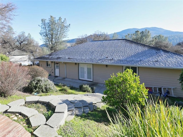 back of property featuring french doors, a mountain view, and a patio area