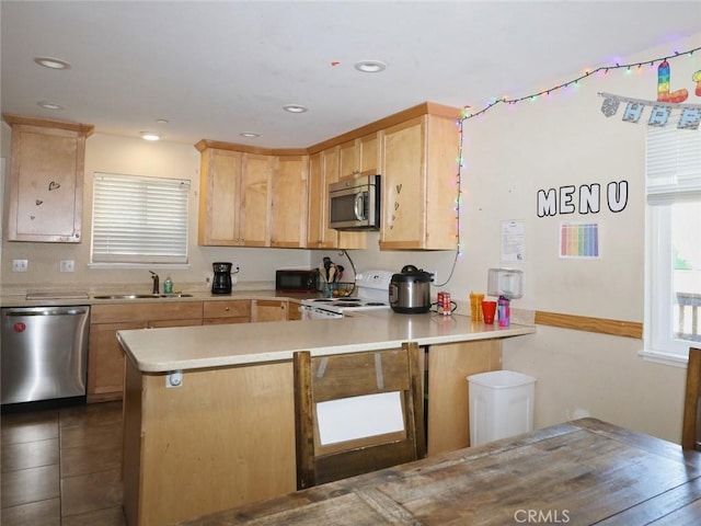 kitchen with appliances with stainless steel finishes, sink, light brown cabinetry, and kitchen peninsula