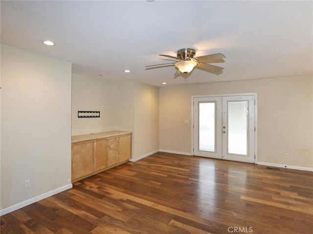 empty room featuring french doors, baseboards, and wood finished floors