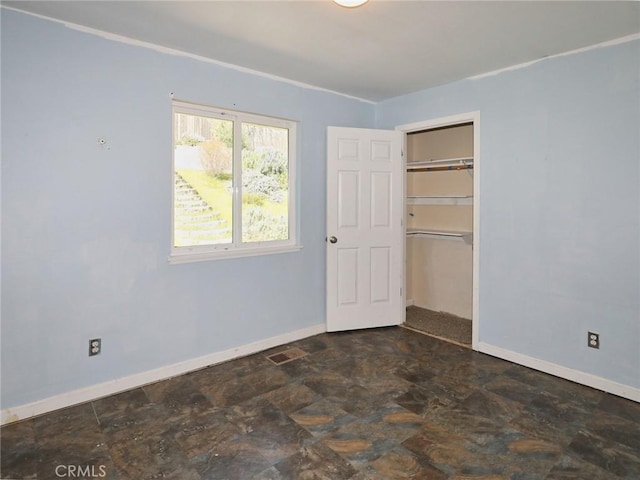 unfurnished bedroom featuring stone finish flooring and baseboards