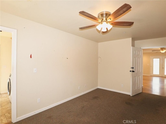 unfurnished room featuring carpet floors, washer / dryer, ceiling fan, and baseboards