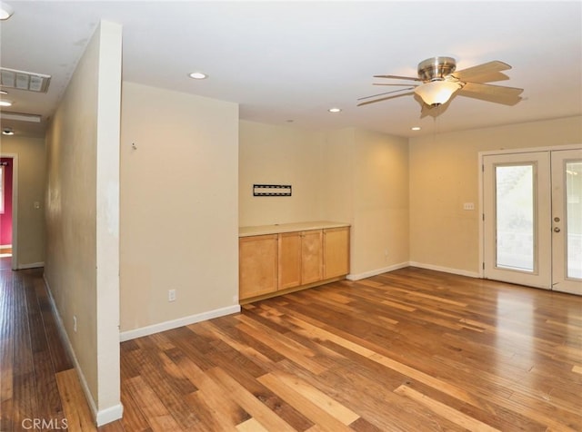 spare room featuring recessed lighting, wood finished floors, a ceiling fan, baseboards, and french doors