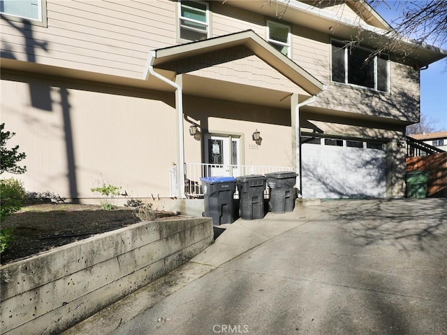 view of exterior entry featuring a garage and driveway