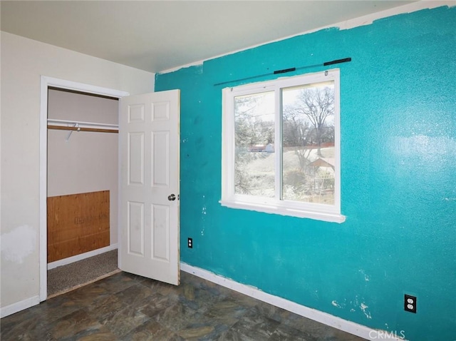 unfurnished bedroom featuring baseboards and a closet