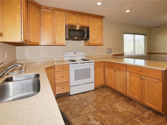 kitchen with white electric range oven, light countertops, stainless steel microwave, a sink, and a peninsula