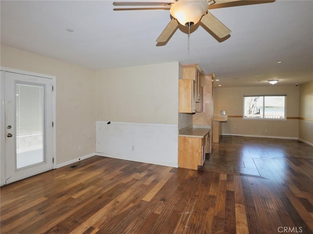 unfurnished room with baseboards, visible vents, and dark wood finished floors