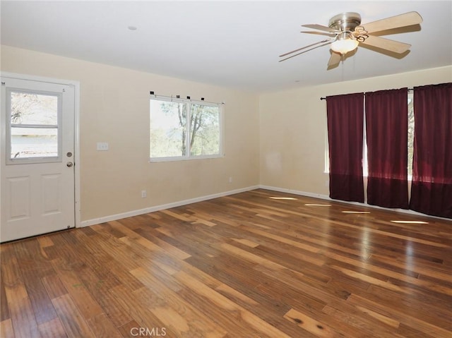 spare room featuring a ceiling fan, baseboards, and wood finished floors