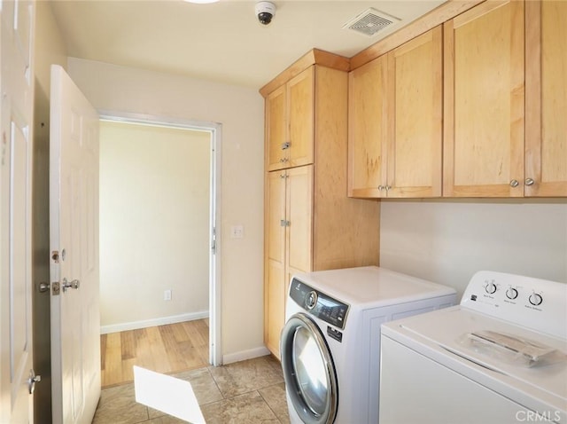 washroom featuring visible vents, cabinet space, washing machine and dryer, light tile patterned flooring, and baseboards