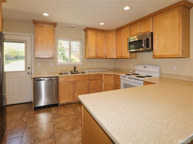 kitchen with recessed lighting, light countertops, light brown cabinetry, appliances with stainless steel finishes, and a sink