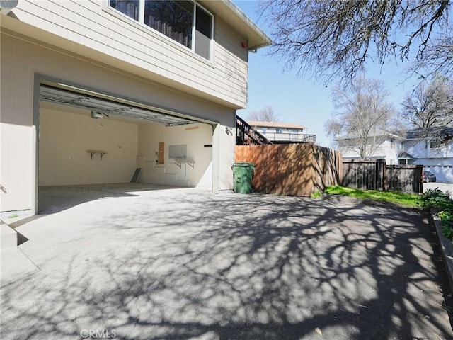 exterior space featuring a garage, fence, and driveway