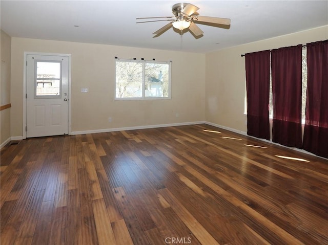 interior space featuring a ceiling fan, baseboards, and wood finished floors