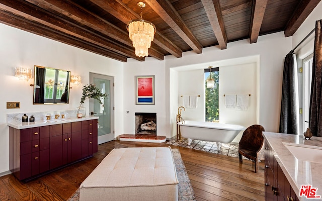 bathroom with beamed ceiling, wood-type flooring, a tub, wood ceiling, and plenty of natural light