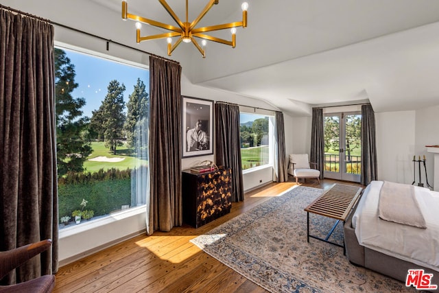 bedroom with multiple windows, wood-type flooring, lofted ceiling, and french doors