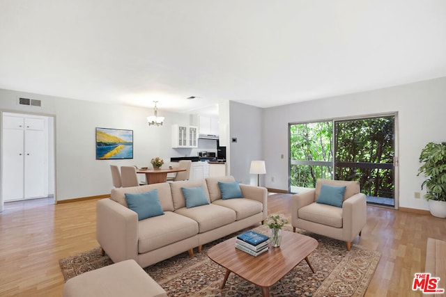 living room with light hardwood / wood-style floors and a chandelier