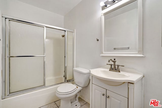 full bathroom with toilet, vanity, bath / shower combo with glass door, and tile patterned flooring