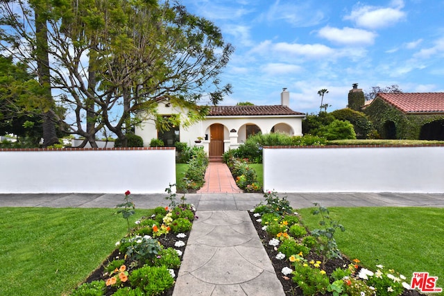 mediterranean / spanish home featuring a front lawn