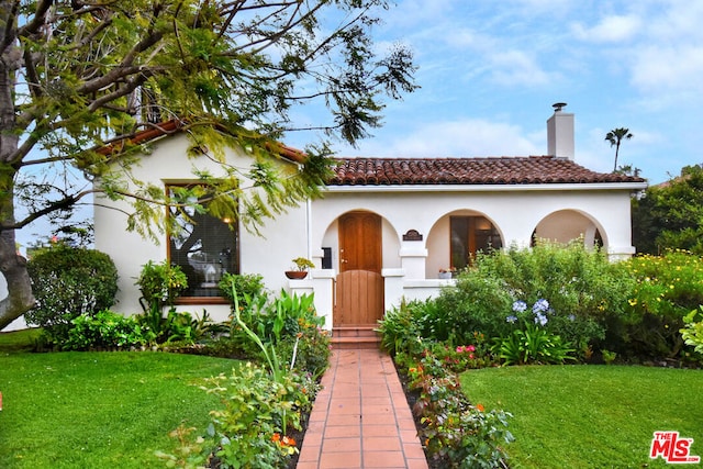 mediterranean / spanish-style house with a front yard