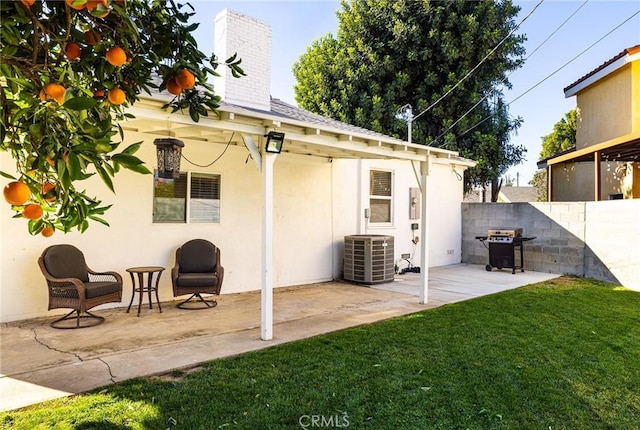 rear view of property featuring central AC, a patio area, and a lawn