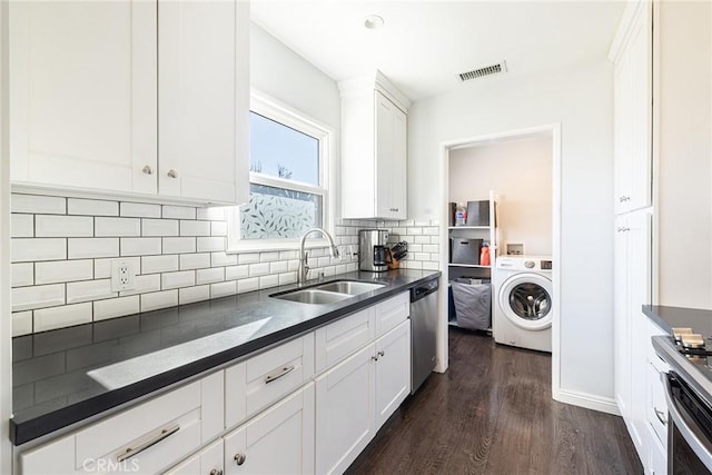 kitchen with washer / dryer, sink, white cabinetry, stainless steel dishwasher, and decorative backsplash