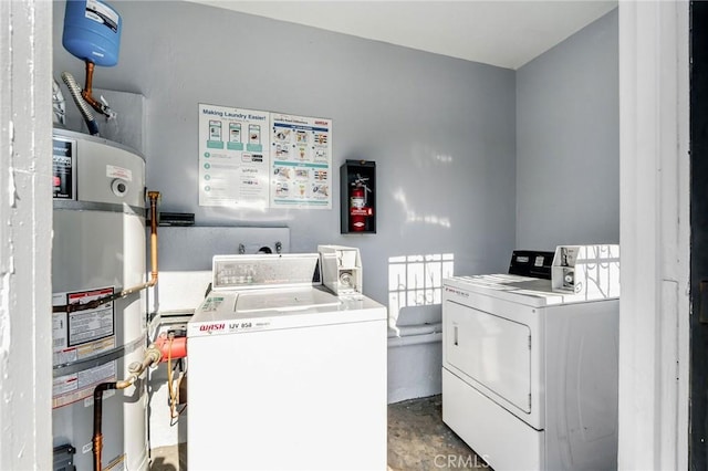 clothes washing area featuring washing machine and dryer and strapped water heater