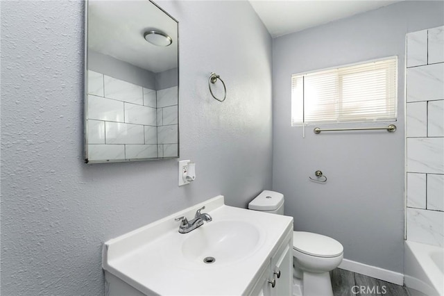 full bath featuring toilet, baseboards, wood finished floors, and vanity