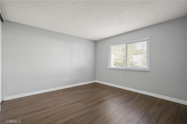 unfurnished room with dark hardwood / wood-style floors and a textured ceiling