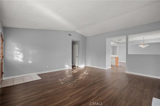 empty room featuring a notable chandelier and vaulted ceiling