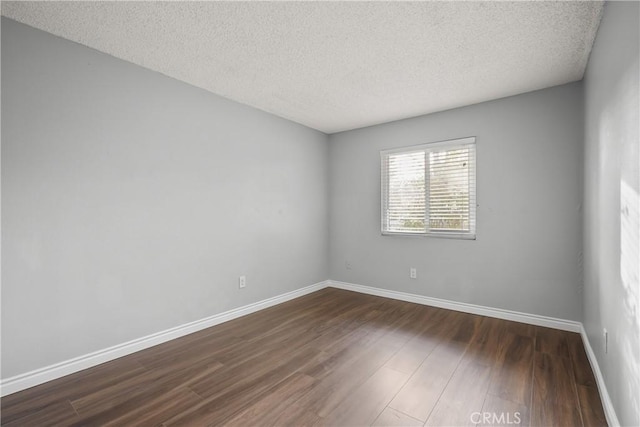 unfurnished room with dark hardwood / wood-style floors and a textured ceiling