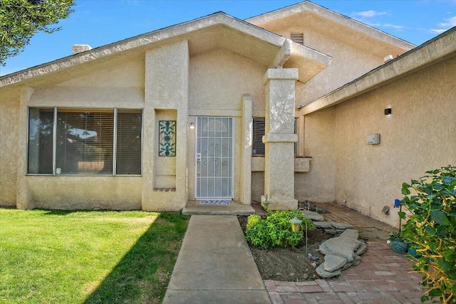 view of exterior entry featuring a yard