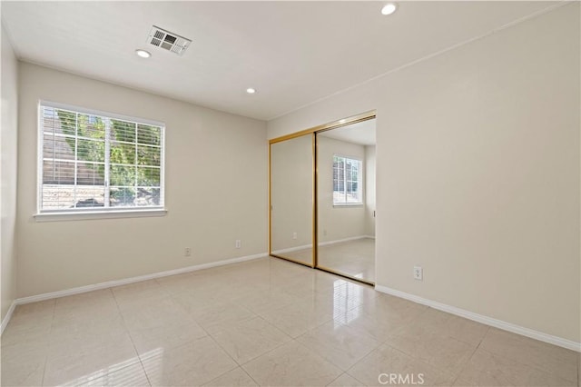 unfurnished bedroom with a closet and multiple windows