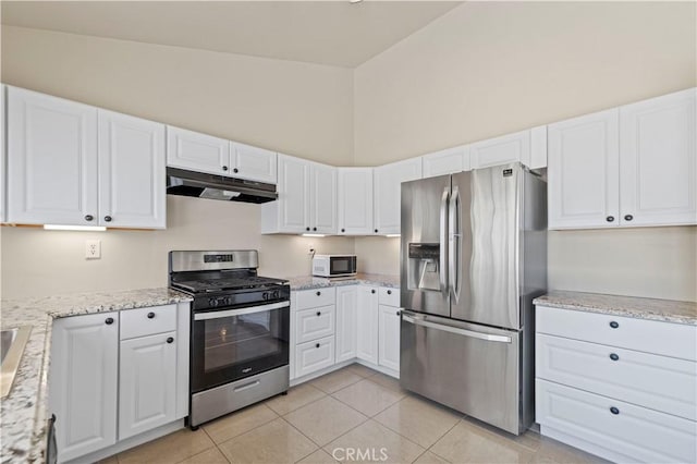 kitchen featuring white cabinetry, appliances with stainless steel finishes, light tile patterned flooring, and high vaulted ceiling