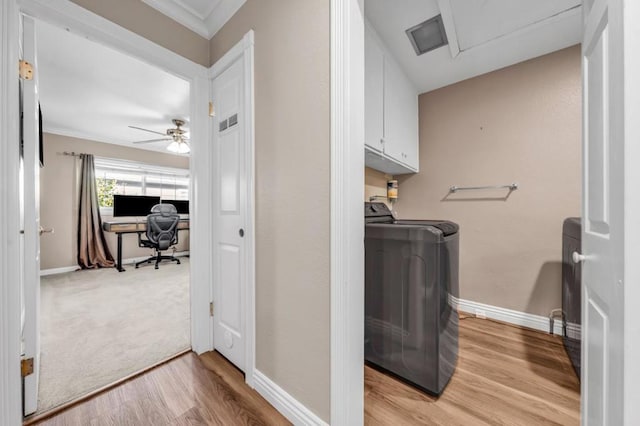 laundry room featuring washer and dryer, cabinets, and light hardwood / wood-style flooring