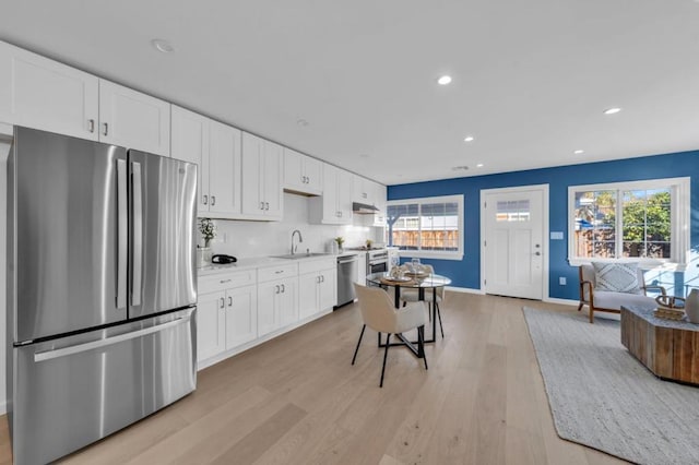 kitchen with white cabinetry, a healthy amount of sunlight, appliances with stainless steel finishes, and light hardwood / wood-style floors