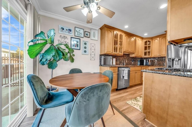 kitchen featuring decorative backsplash, ceiling fan, stainless steel appliances, crown molding, and light wood-type flooring