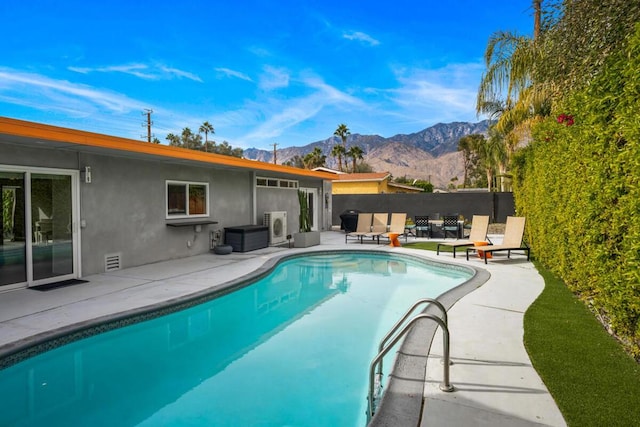 view of swimming pool featuring a patio, a mountain view, and ac unit