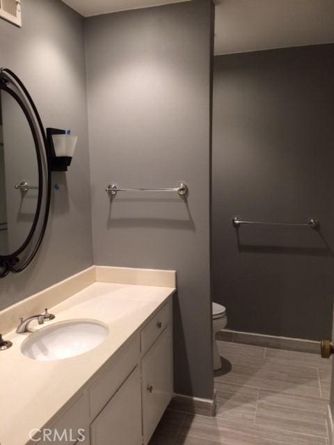 bathroom featuring tile patterned floors, vanity, and toilet