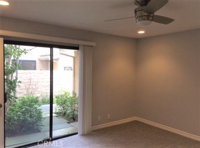 empty room featuring ceiling fan and carpet