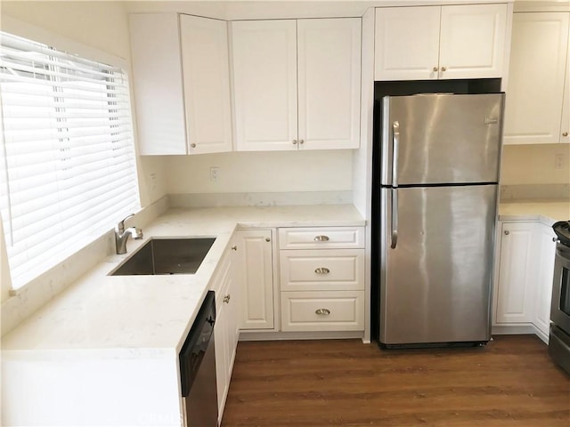 kitchen with stainless steel appliances, white cabinetry, sink, and dark hardwood / wood-style floors