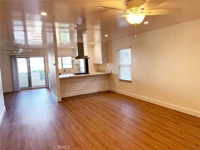 unfurnished living room with hardwood / wood-style flooring and ceiling fan